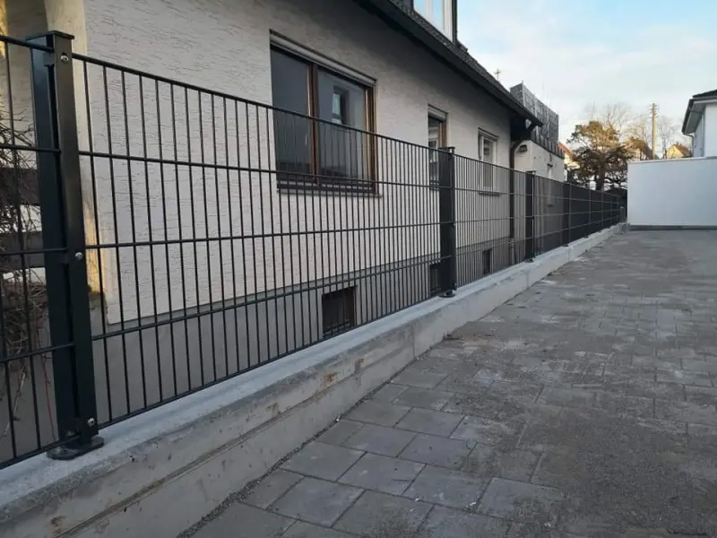 Anthrazitfarbener Doppelstabmattenzaun auf einer Mauer